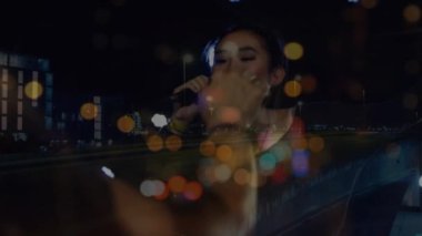 Mutlu Asyalı kadın şarkıcının konserindeki bulanık gece yolu trafiğinin animasyonu. Müzik, eğlence ve gece hayatı konsepti dijital olarak oluşturulmuş video.