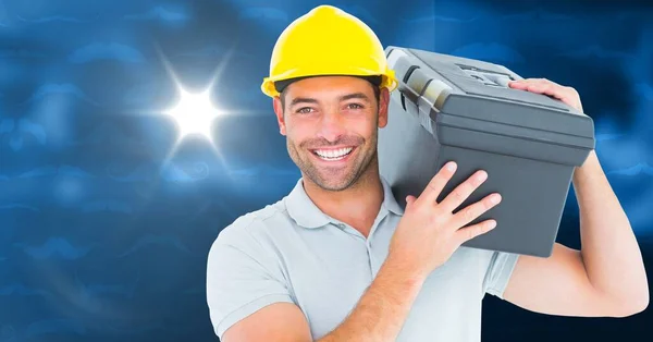 Caucasian male worker carrying a case against spot of light on blue background with copy space. repair service concept