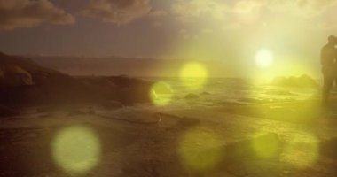 Kayaların üzerinde birlikte duran Afro-Amerikan çifti karşısında parlayan sarı ışık lekeleri. Aşk ve ilişki kavramı