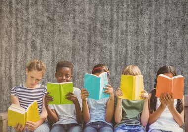 Çeşitli öğrencilerden oluşan bir grup, kopya alanı ile dokulu gri arkaplan karşısında kitap okuyor. okul ve eğitim kavramı