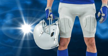 Erkek rugby oyuncusunun orta bölümü mavi arka planda kask takıyor. fitness