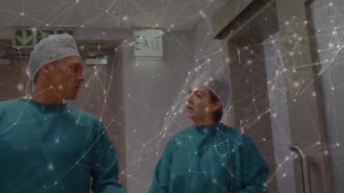 Ameliyathanede iki beyaz cerrah arasındaki bağlantı ağının animasyonu. küresel tıp, covid 19 pandemik konsept sırasında sağlık hizmetleri dijital olarak üretilen video.