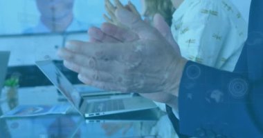 İş adamlarının el çırpması üzerine dijital ekranda çeşitli verilerin animasyonu. İş, işbirliği, iletişim ve teknoloji konsepti dijital olarak oluşturulmuş video.