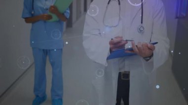 Çeşitli doktorların gülümsemesi üzerine veri işleme animasyonu. Küresel tıp ve dijital arayüz kavramı dijital olarak oluşturulmuş video.