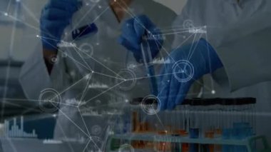 Laboratuvarda çalışan yüz maskesi takan iki kadın bilim adamına karşı bir bağlantı ağı. Küresel ağ ve tıbbi araştırma teknolojisi kavramı