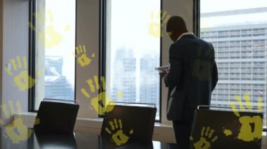 Animation of yellow hands over caucasian businessman in office. Communication, business, and technology concept digitally generated video.