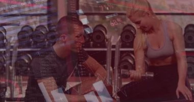 Spor salonunda egzersiz yapan beyaz bir çiftin veri işleme animasyonu. Küresel spor ve dijital arayüz kavramı dijital olarak oluşturulmuş video.