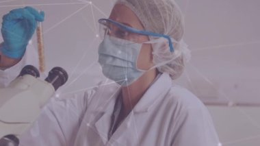 Laboratuvarda yüz maskesi takan kadın bilim adamlarına karşı bir bağlantı ağı var. Küresel ağ ve tıbbi araştırma teknolojisi kavramı
