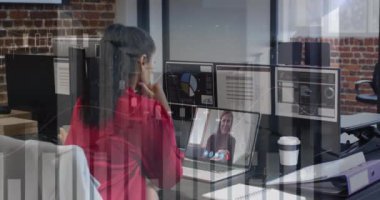 Animation of financial graphs over biracial woman having video call in office. Business, communication and technology concept digitally generated video.