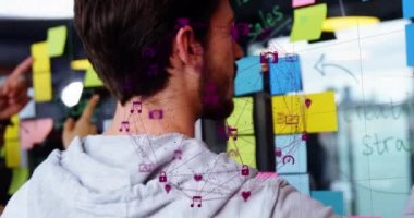 Animation of data processing over diverse business people taking notes on glass wall. Global business and digital interface concept digitally generated video.