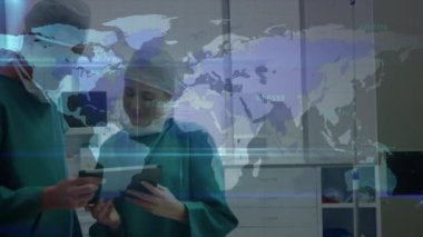 Data processing over world map against male and female surgeon using digital tablet at hospital. Global finance and medical healthcare technology concept