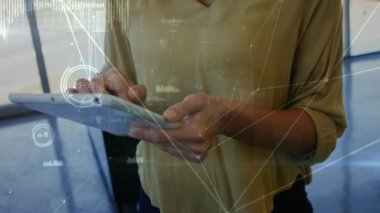 Tablet kullanan iki ırklı iş kadınının veri işleme animasyonu. küresel iş ve dijital arayüz kavramı dijital olarak oluşturulmuş video.