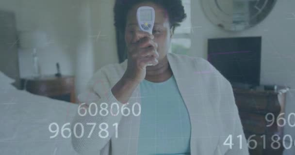 Multiple Changing Numbers African American Senior Woman Measuring Her Temperature — Stock video