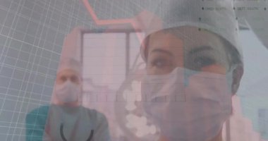 Animation of financial data over caucasian female and male surgeons. Health, medicine, finance and economy concept digitally generated video.