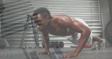 Animation of graphs over african american man exercising at gym, doing push ups. Sporty, active lifestyle, staying in shape concept digitally generated video.