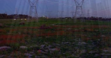 Günbatımında elektrik direkleri üzerinden finansal grafiklerin ve verilerin animasyonu. Dijital olarak üretilen enerji, elektrik, finans ve ekonomi konsepti.