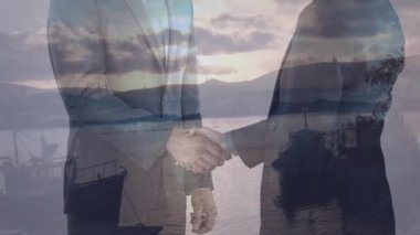 Çeşitli iş adamlarının manzara üzerinde el sıkışması. Küresel iş ve dijital arayüz kavramı dijital olarak oluşturulmuş video.