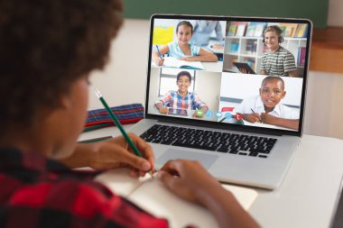 Afro saçı olan Afrikalı bir kız. İnternette dersini bilgisayarda öğrenirken. Ev, video çağrısı, değiştirilmemiş, çocukluk, kablosuz teknoloji, eğitim, öğrenci ve e-öğrenim kavramı.