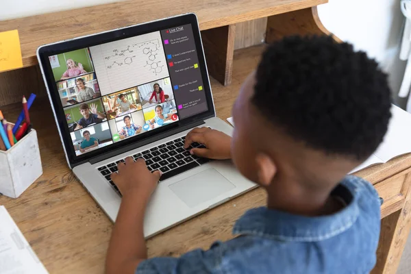 African american boy typing message on laptop during video call while learning in online class. Home, screen, unaltered, childhood, wireless technology, education, student and e-learning concept.