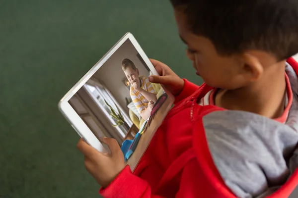 デジタルタブレット画面上のビデオ通話を通じて友人を見て出産少年の高い角度ビュー オンライン 変更されていない 子供時代 無線技術 Eラーニングの概念 — ストック写真