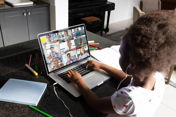 African american girl with afro hair learning in online class over video call on laptop at home. Screen, internet, unaltered, childhood, wireless technology, education, student and e-learning.