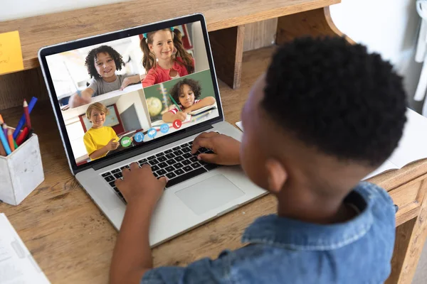 African american boy looking at laptop screen with multiracial students during online class. Unaltered, internet, childhood, wireless technology, education, internet, video call, e-learning concept.