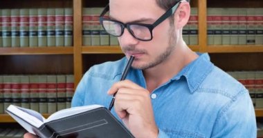 Animation of caucasian man reading book over library. National book lovers day and celebration concept digitally generated video.