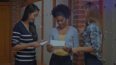 Animation of network of connections with icons over diverse students talking in school. school, education, learning and connections concept digitally generated video.