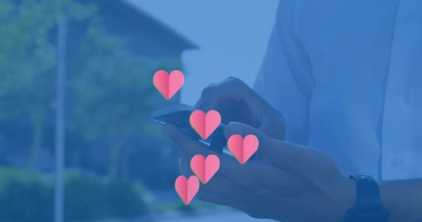Animation Hearts Floating Hands Caucasian Man Using Smartphone Social Media — Stockvideo