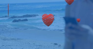 Kafkasyalı bir kadının ellerinde akıllı telefon kullanarak yüzen kalplerin animasyonu. Sosyal medya, iletişim ve teknoloji konsepti dijital olarak oluşturulmuş video.