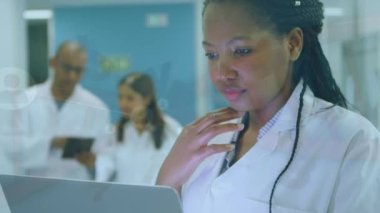 Tablet kullanan Afrikalı Amerikalı kadın laboratuvar çalışanı üzerindeki bilimsel verilerin animasyonu. Bilim, sağlık, tıp ve teknoloji konsepti dijital olarak üretilen video.