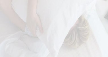 Animation of caucasian woman embracing pillow and lying. National lazy day and celebration concept digitally generated video.