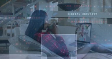 Animation of scanning, cyber crime over biracial woman having video call on laptop. Internet safety, data protection, communication and technology concept digitally generated video.