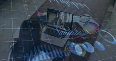 Animation of financial graphs and data over african american female designer having video call. economy, finance and business concept digitally generated video.