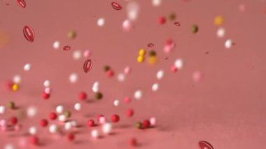 Pembe arka plan üzerine düşen topların animasyonu. Beyaz yüzeye düşen serpintilerin üzerinde görünen yaprakların canlandırılması.
