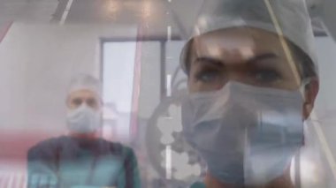 Animation of road traffic over caucasian female surgeon in face mask. health, medicine, accidents and city life concept digitally generated video.