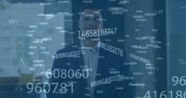 Animation of data processing over biracial businessman smiling in office. Global business and digital interface concept digitally generated video.
