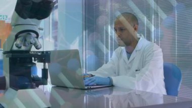 Animation of scientific data over afrcian american male lab worker using laptop. science, health, medicine and technology concept digitally generated video.
