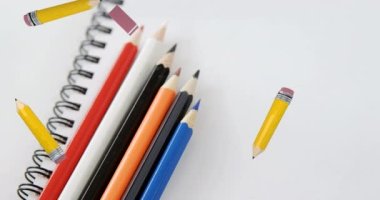 Animation of back 2 school text and stationery moving over coloured pencils and school notebook. school, education and study concept digitally generated video.