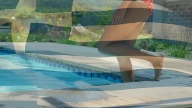 Yüzme havuzuna giren melez bir kadının orta kesiminde Yunan bayrağının canlandırılması. Tatiller, tatiller ve arkadaş konseptiyle geçirilen zaman dijital olarak oluşturulmuş video.