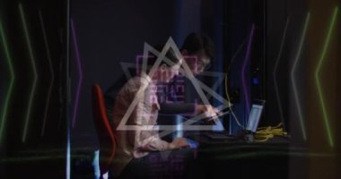 Animation of qr code over diverse couple using laptop in server room. Cloud computing, digital interface and security concept digitally generated video.