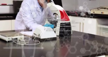 Mikroskop kullanan çift ırklı erkek laboratuvar çalışanı üzerinde kimyasal formüllerin ve veri işlemenin animasyonu. Kimyasal formüllerin animasyonu ve bilgisayar kullanan beyaz kadın laboratuvar çalışanı üzerinde veri işlemesi.