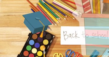 Animation of mortarboard, schoolbooks and stationery over back to school text and art equipment. school, education, technology and study concept digitally generated video.
