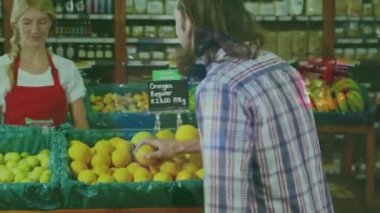 Finansal grafiklerin, marketteki mutlu beyaz kadın satıcı ve erkek müşteri üzerine animasyonu. ekonomi, finans, alışveriş ve dijital olarak üretilen küçük bağımsız iş konsepti.