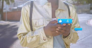 Akıllı telefon kullanan Afro-Amerikan bir kadının ellerinde sosyal medya tepkisinin animasyonu. Sosyal medya, ağ, iletişim ve teknoloji konsepti dijital olarak oluşturulmuş video.