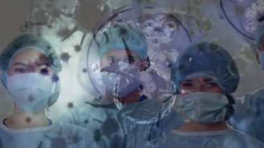 Ameliyathanede yüz maskesi takan çeşitli cerrahlar üzerinde kovid 19 hücrenin animasyonu. küresel covid 19 salgın, ilaç ve sağlık hizmetleri konsepti dijital olarak oluşturulmuş video.