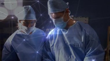 Animation of network of connections over caucasian surgeons during surgery. global medicine and digital interface concept digitally generated video.
