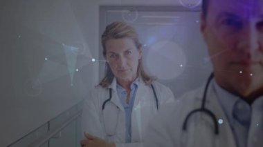 Animation of network of connections over two diverse doctors. Global medicine, technology, data processing and digital interface concept digitally generated video.
