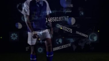 Animation of numbers and data processing over african american football player on football pitch. global sports, competition and data processing concept digitally generated video.