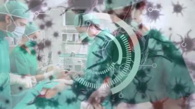 Animation of scope covid 19 cells over diverse surgeons wearing face masks in operating theatre. global covid 19 pandemic, medicine and healthcare services concept digitally generated video.